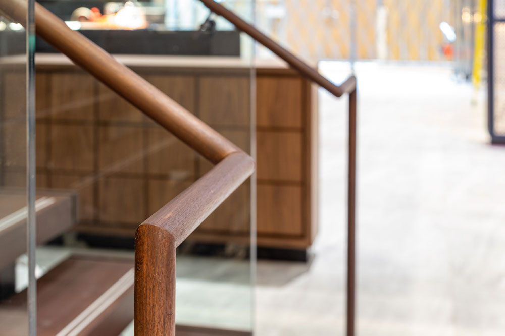 glass side mounted round wood handrails